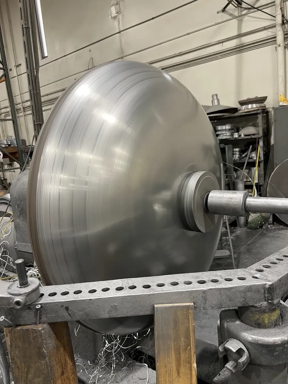 Large aluminum disc spinning on the lathe, blurred by motion