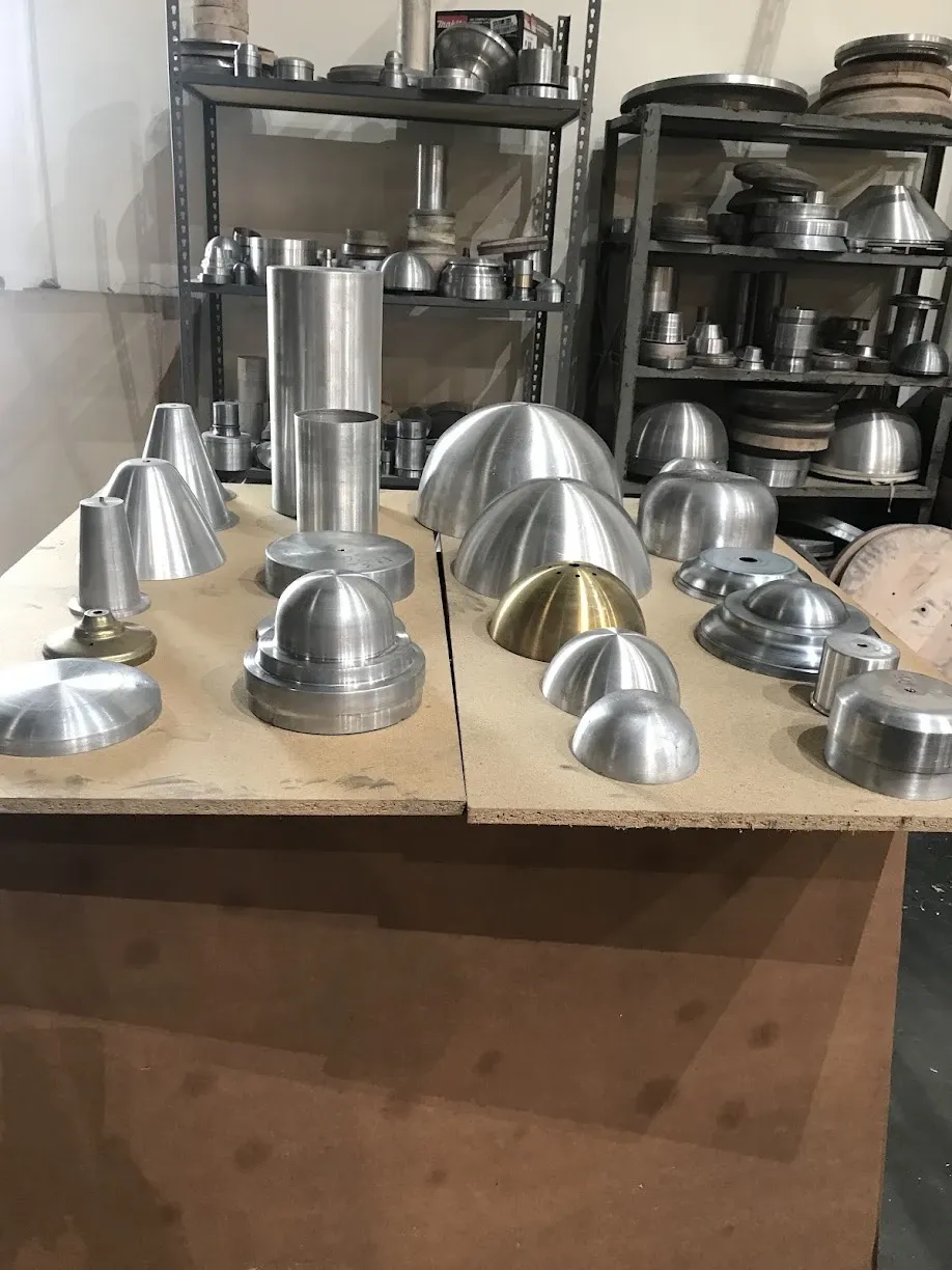 A table of spun aluminum and brass parts including domes, cones and cylinders